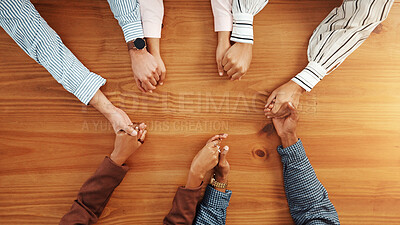 Buy stock photo Holding hands, collaboration and business people by table in office for synergy, unity or support. Teamwork, top view and group of corporate employees with solidarity, trust or meeting in workplace.