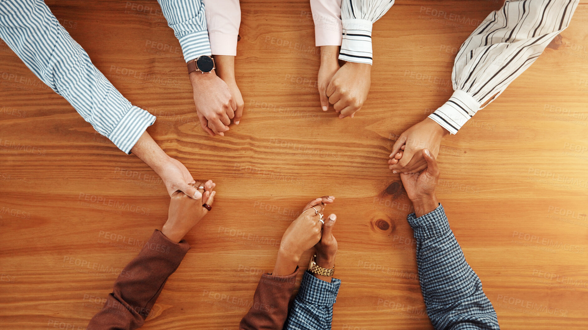 Buy stock photo Holding hands, collaboration and business people by table in office for synergy, unity or support. Teamwork, top view and group of corporate employees with solidarity, trust or meeting in workplace.