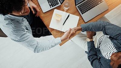 Buy stock photo Business people, meeting or above with handshake for partnership, deal or introduction in office. Top view, employees or colleagues shaking hands with laptop or book for b2b or agreement in workplace