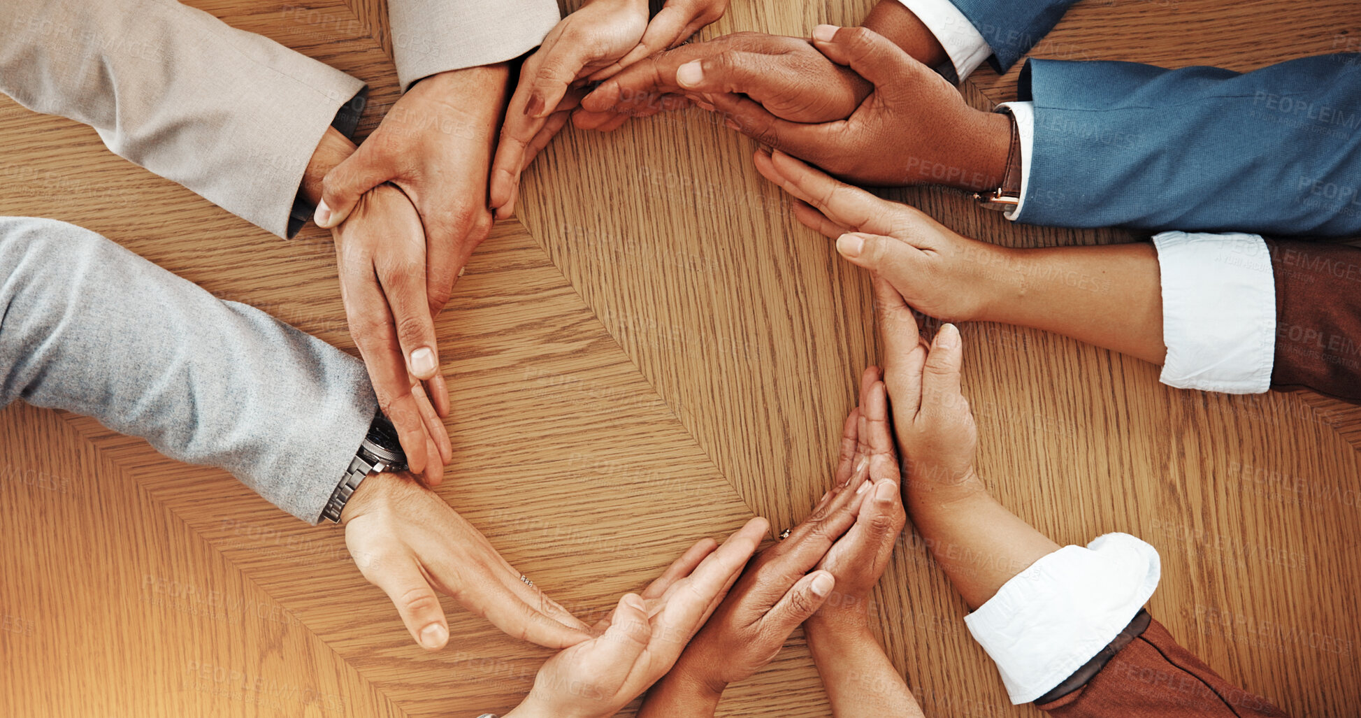 Buy stock photo Business people, hands together and meeting in circle above for unity or mission on wooden table. Top view, group or community with diversity for inclusion, collaboration or teamwork on mockup space