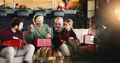 Buy stock photo Christmas, gift and box with family on sofa for holiday season, bonding or support. Festive celebration, smile or xmas present with people in living room of home for generation love, package or relax