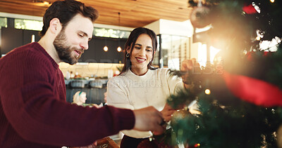Buy stock photo Christmas, couple and tree decoration in home for christian holiday and festive celebration. Happy man, woman and hanging ornaments for xmas to help with bauble for december event in living room
