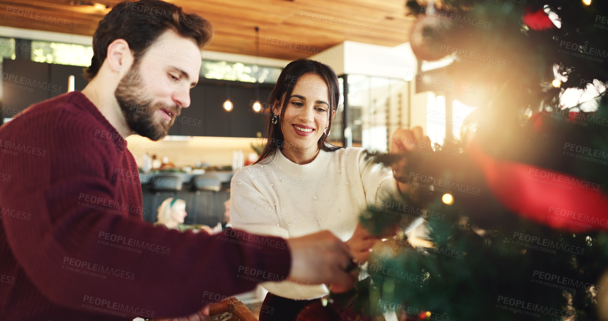 Buy stock photo Christmas, couple and tree decoration in home for christian holiday and festive celebration. Happy man, woman and hanging ornaments for xmas to help with bauble for december event in living room