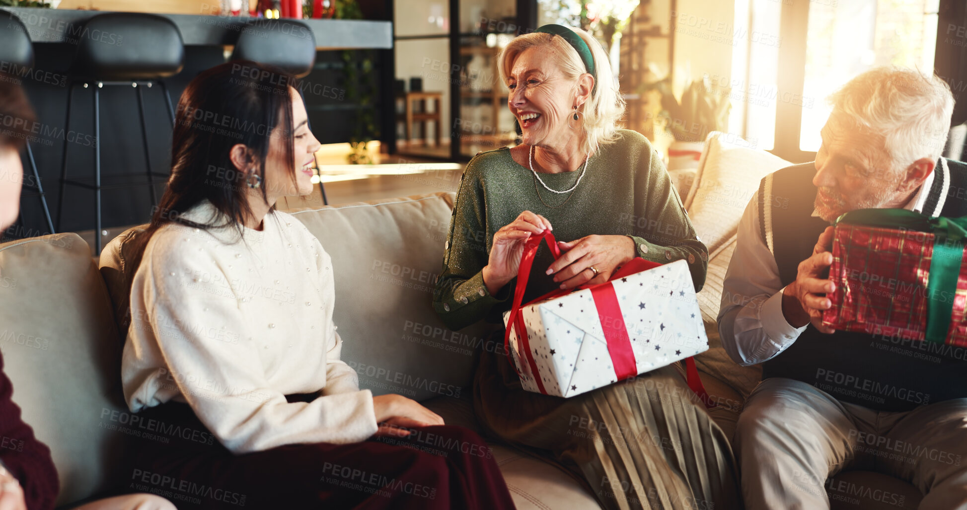 Buy stock photo Christmas, happy and senior parents with gift on sofa for celebration, giving presents and surprise. Family, home and mature mom, dad and woman with box for festive season, tradition and xmas holiday