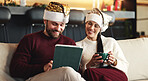 Xmas, coffee or couple on couch, tablet or bonding together with social media, love or app. Home, Christmas or man with woman, holiday season or eggnog with online entertainment, festive or tradition