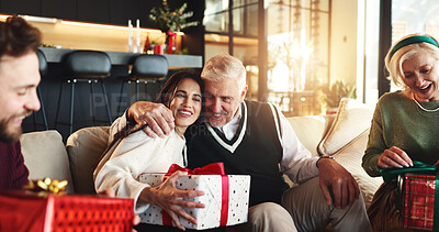 Buy stock photo Christmas, gift and hug with family on sofa for holiday season, bonding and support. Festive celebration, smile and xmas present with people in living room of home for love, package and relax