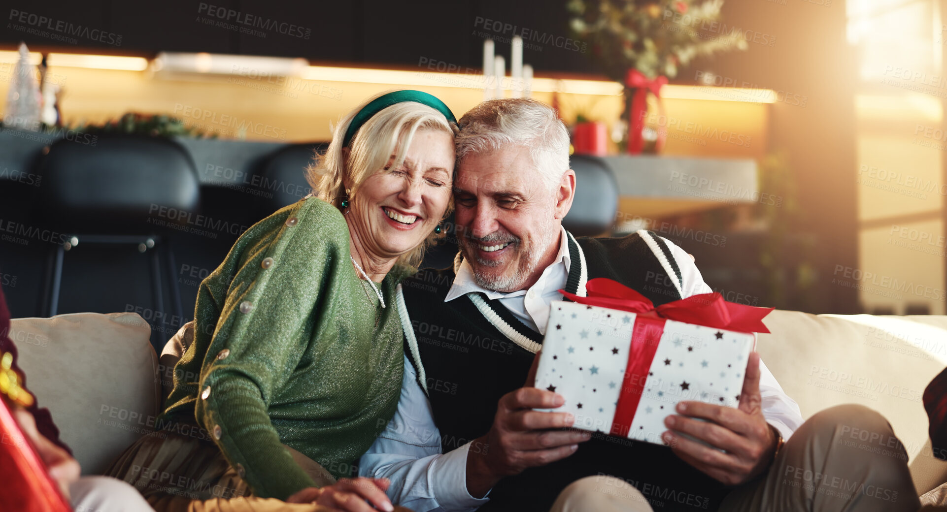 Buy stock photo Christmas, hug or senior couple with gift for retirement, support or festive celebration. Care, smile or woman giving xmas present for gratitude, elderly man or love for holiday tradition in home 