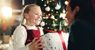 Buy stock photo Girl, happy and mom with gift, Christmas tree and thanks with love, bonding or festive holiday. Child, mother and daughter with box, package or excited for present at xmas celebration at family house