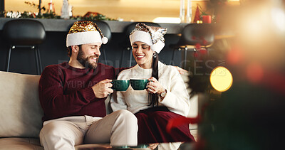 Buy stock photo Christmas, cheers and couple with coffee in home for festive morning with santa hat for celebration. Happy, love and man with woman on sofa for relax, bonding and drinking eggnog for xmas together.