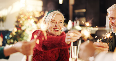 Buy stock photo Christmas, sparkler and party with family in home for celebration, social reunion and festive season. Merry xmas, cheers and mature woman with people in living room for holiday, support and event