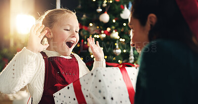 Buy stock photo Girl, mom and surprise with gift, Christmas tree and thanks with love, bonding or festive holiday. Child, mother and daughter with box, package or wow for present at xmas celebration in family house