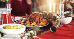 Food, dinner table and christmas meal with family for thanksgiving or festive celebration in home. People, chicken and decor with dinning setting for eating, bonding or december holiday together