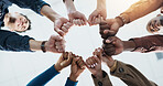 Below, business and people with fist together for team building, solidarity and trust with motivation. Staff, scrum and huddle in circle with collaboration, employees unity and synergy for connection