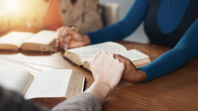 Buy stock photo Hand holding, Bible and people praying with religion, guidance or support with scripture for worship. Christianity, faith and group together by table, book of God and praise with spiritual education