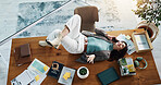 Above, music and relax with woman on table in office for break, radio entertainment or wellness. Audio, headphones and sound streaming with business employee lying on desk in workplace for rest
