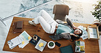 Above, music and relax with woman on desk in office for break, radio streaming or wellness. Audio, headphones and sound entertainment with business employee lying on table in workplace for rest
