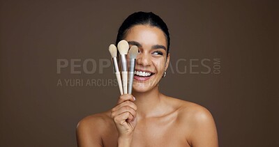 Buy stock photo Happy woman, makeup and beauty with brushes in studio for cosmetics on a brown background. Female person, model or smile with product tools for cosmetology, foundation or blending shade on space