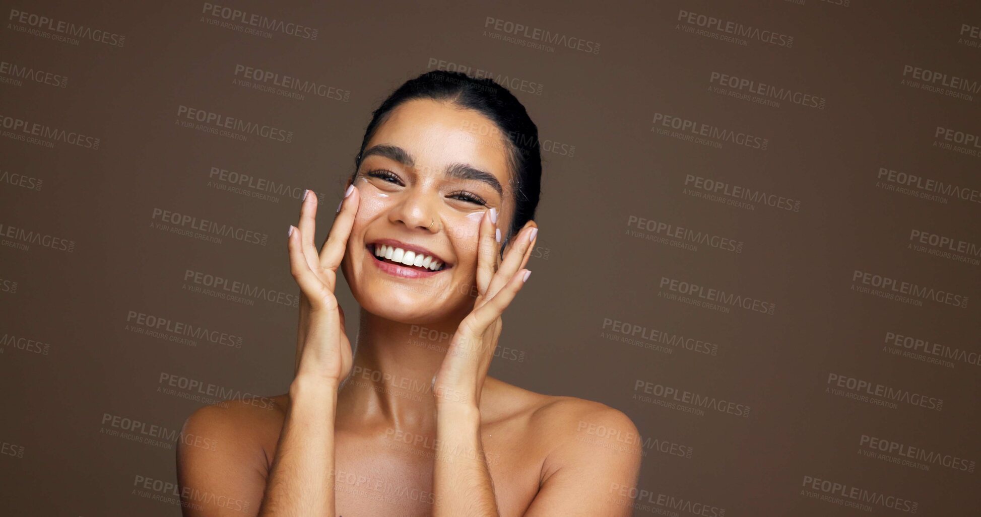 Buy stock photo Beauty, woman and happy with face cream in studio for collagen treatment, hydration and self care. Mockup, girl and cosmetics application on brown background for skin glow, anti aging and dermatology