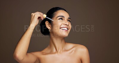 Buy stock photo Beauty, serum and thinking with woman in studio for antiaging cosmetics or dermatology treatment. Dropper, idea and smile of happy model on brown background to apply liquid skincare product to face