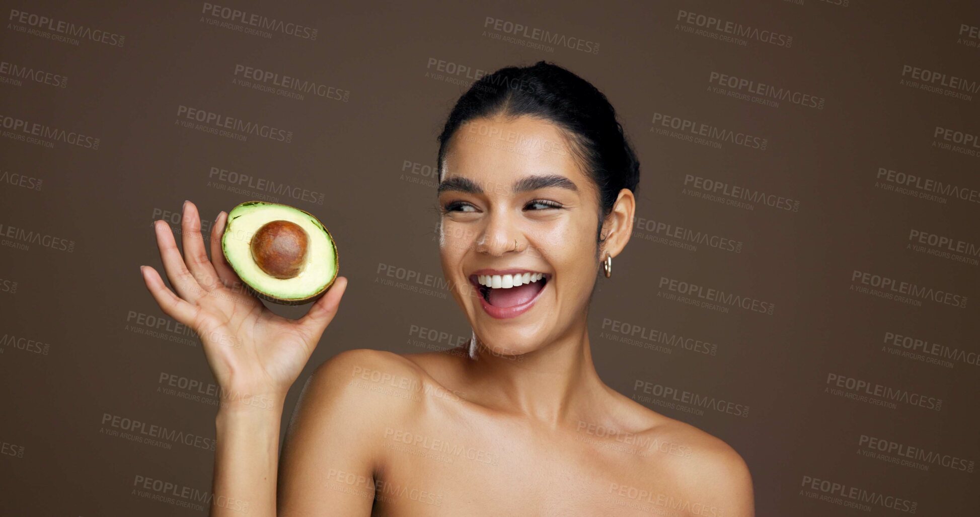 Buy stock photo Woman, avocado and happy in studio for skincare, laugh and sustainable beauty by background. Girl, model and thinking with food for natural wellness, organic fruit and excited for results with glow