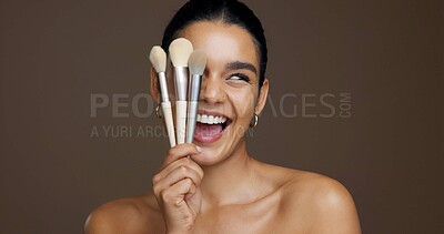 Buy stock photo Beauty, woman and happy with makeup brushes in studio to apply cosmetics, skin glow and foundation. Mockup space, excited and girl with skincare product for concealer or self care on brown background