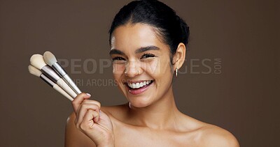 Buy stock photo Beauty, woman and portrait with makeup brushes in studio for skincare, skin glow and foundation. Space, happy or person with cosmetic tools to apply concealer and self care on brown background