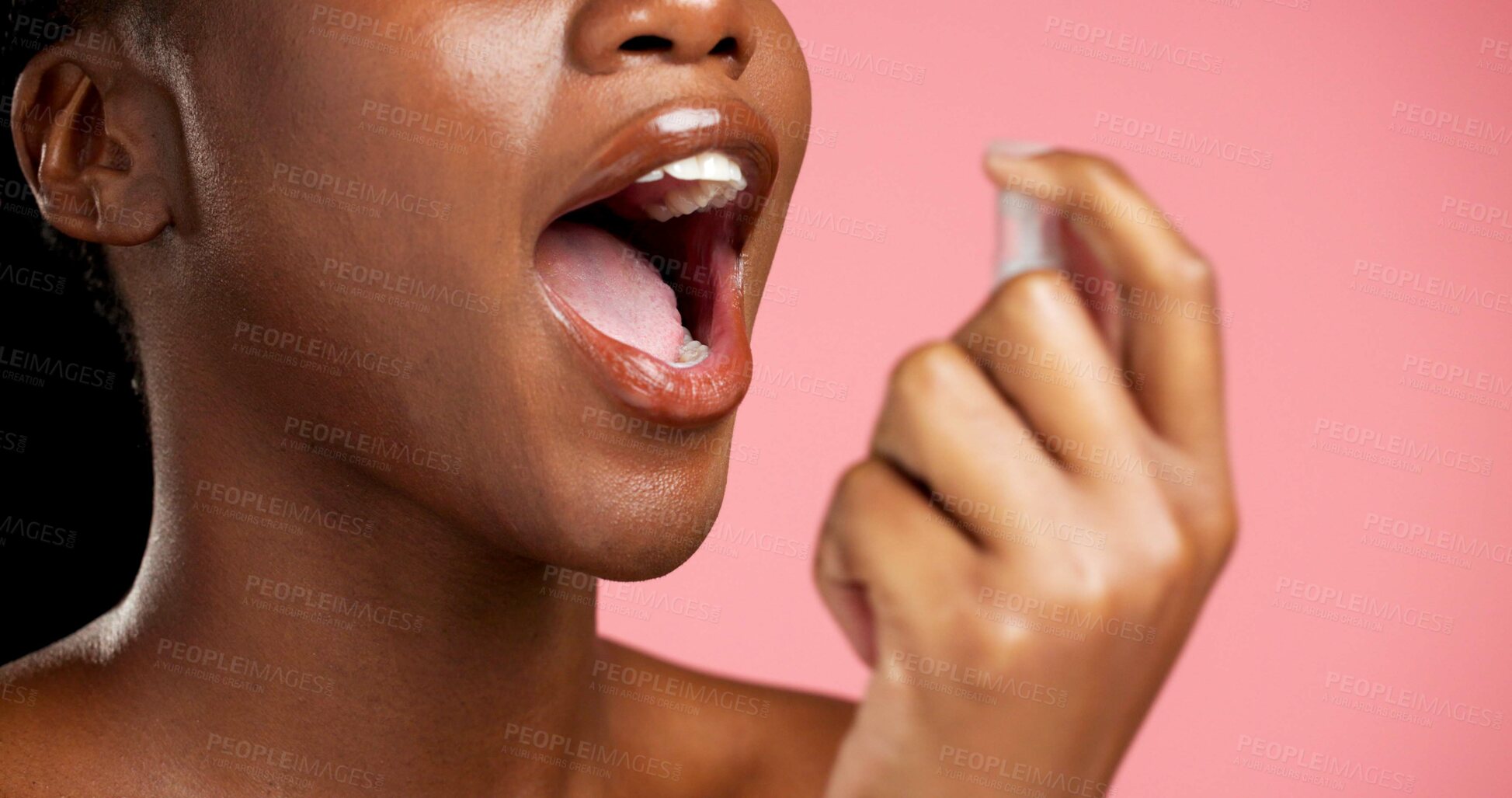 Buy stock photo Black woman, hands and mouth with spray for bad breath or oral care on a pink studio background. Closeup, female person or model with perfume or cologne or mist for scent, odor or dental hygiene