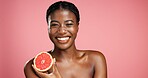 Portrait, black woman and grapefruit for beauty in studio for vitamin c, brighten skin and natural detox. Female person, fruit and organic benefits, skincare and dermatology shine on pink background