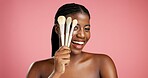 Portrait, black woman and makeup brushes in studio background for beauty, makeover and glamour. Happy, female person and cosmetic tools for transformation, foundation application and aesthetics flow