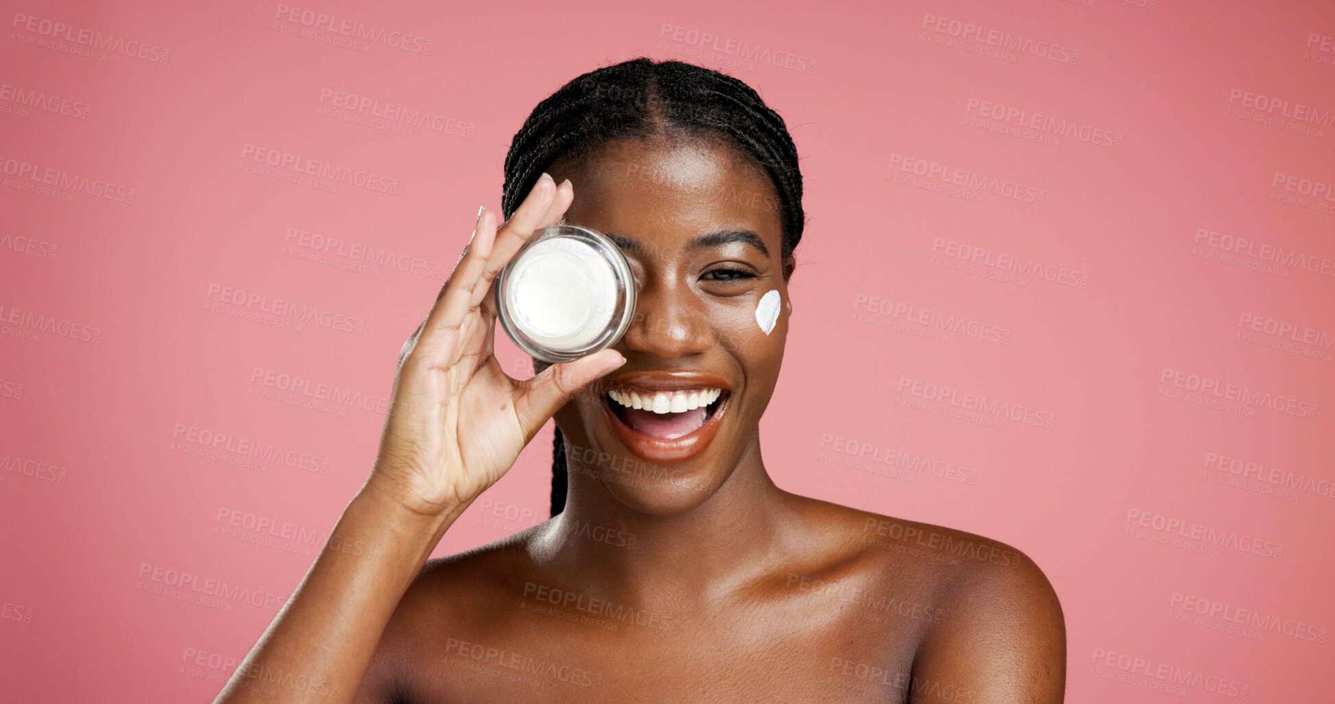 Buy stock photo Portrait, black woman and smile with cream in studio for beauty, facial hydration and treatment. Happy, female person and lotion product for self care, sunscreen benefits and shine on pink background