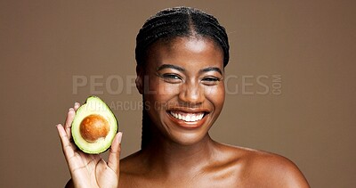 Buy stock photo Dermatology, avocado and portrait of black woman in studio with natural, antioxidants or face glow. Happy, beauty and African female person with fruit for moisturizing skincare by brown background.