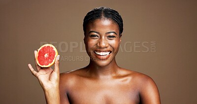 Buy stock photo Happy, black woman and portrait with grapefruit for skincare or health on a brown studio background. Face, female person or model with beauty, smile or natural organic fruit for vitamin c or detox
