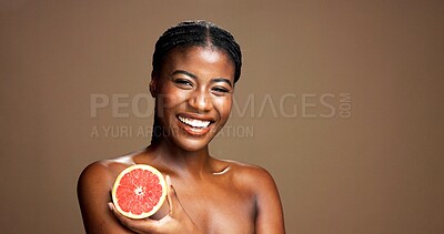 Buy stock photo Skincare, happy and portrait of black woman with grapefruit in studio for natural, organic or facial glow. Dermatology, beauty and African person with citrus for face brightening by brown background.