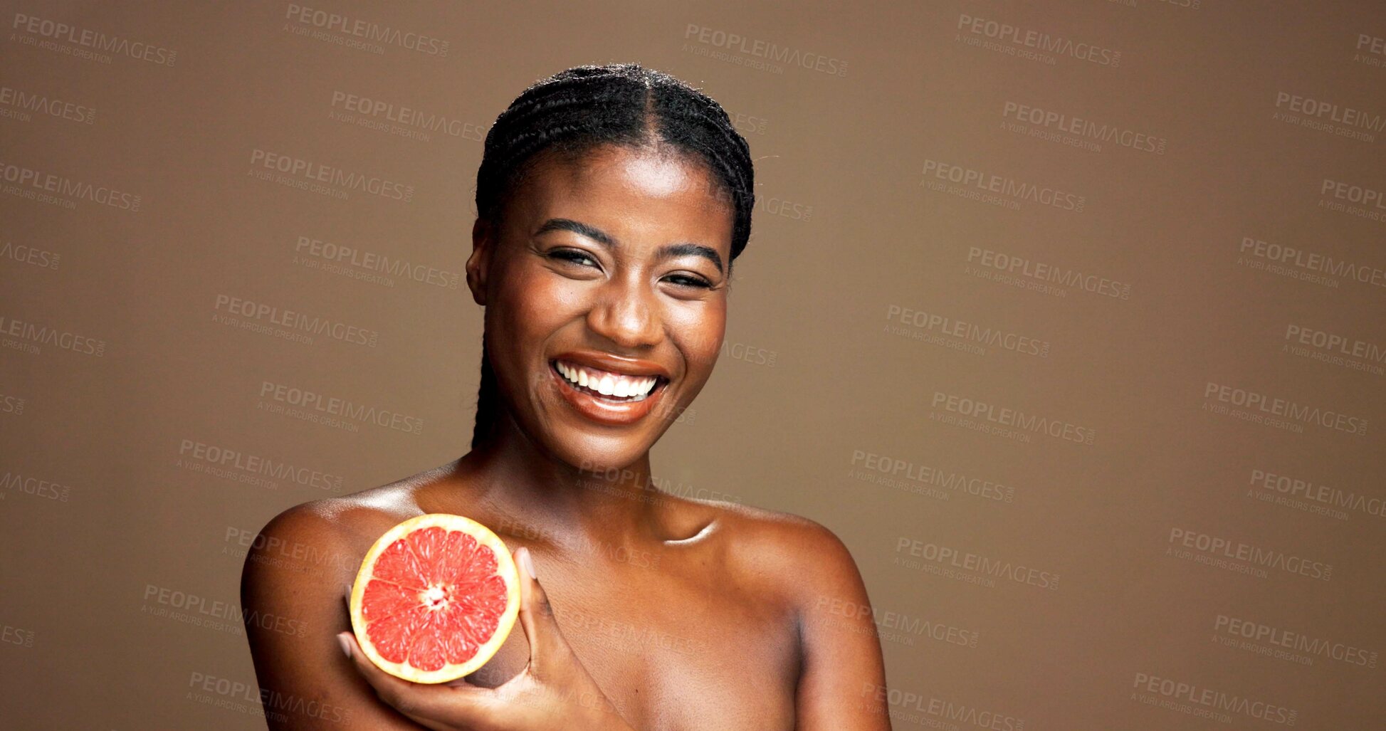 Buy stock photo Skincare, happy and portrait of black woman with grapefruit in studio for natural, organic or facial glow. Dermatology, beauty and African person with citrus for face brightening by brown background.
