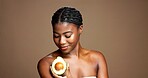 Happy, woman and skincare with avocado, cosmetics and treatment for bodycare, self care or wellness. Studio background, natural benefits and black person with fruit for healthy skin and mockup space