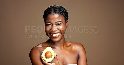 Buy stock photo Natural, avocado and portrait of black woman in studio with skincare, antioxidants or face glow. Happy, beauty and African female person with fruit for moisturizing dermatology by brown background.