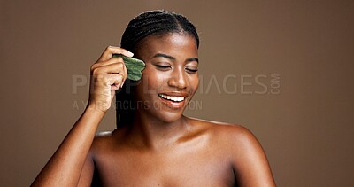 Buy stock photo Facial massage, gua sha and skincare with black woman on studio background space for dermatology or wellness. Beauty, jade stone and smile with model on banner to relax skin for antiaging routine