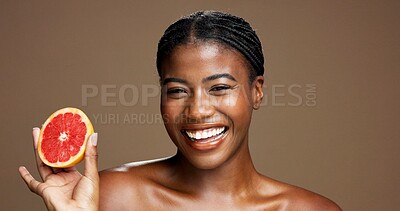 Buy stock photo Happy, black woman or portrait with grapefruit for skincare or health on a brown studio background. Face, female person or model with smile or natural organic fruit for vitamin C, diet or fiber