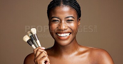 Buy stock photo Makeup, brush and smile with portrait of black woman in studio for cosmetics, beauty product and foundation. Self care, glow and concealer with person and tools on brown background for makeover