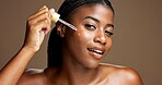 Serum, cosmetics and portrait of black woman in studio for beauty product, skincare and dermatology. Glow, hyaluronic acid and self care with person and dropper on brown background space for retinol