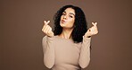 Finger heart, kiss and portrait of woman in studio for support, kindness and thank you. Gratitude, pouting and emoji sign with person on brown background space for love gesture and care symbol