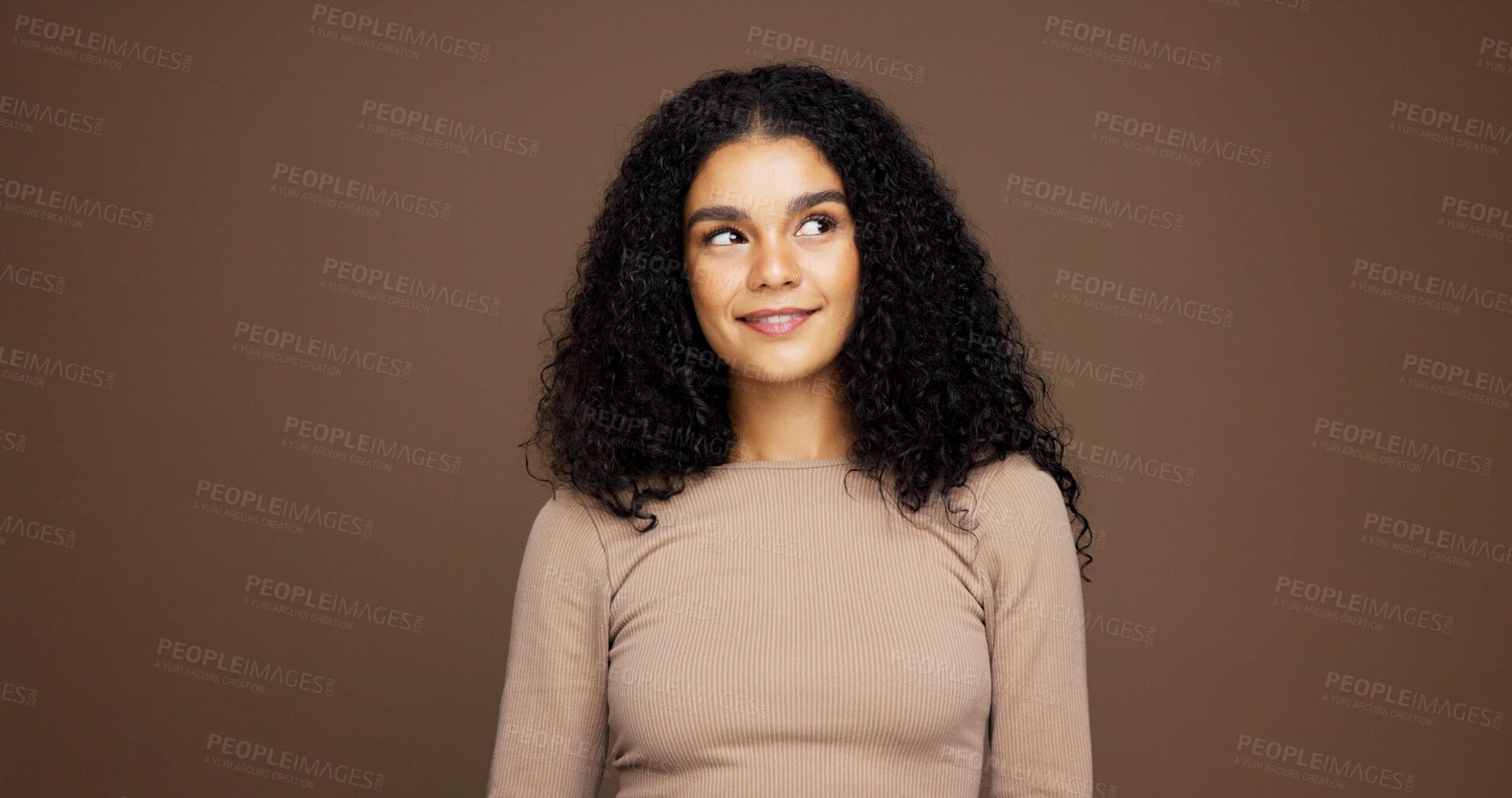 Buy stock photo Thinking, smile and woman with hair care in studio with ideas for natural, beauty or cosmetics. Happy, choice and female person with decision for healthy curly hairstyle for glow by brown background.