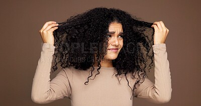Buy stock photo Curly, hair and woman in studio with damage, frizz problem and dry texture on brown background. Hairdresser, salon and person with worry for haircare treatment, grooming routine and shampoo products