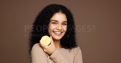 Buy stock photo Portrait, woman and lemon for beauty in studio for vitamin c, brighten skin and natural detox. Female person, citrus and fruit for organic benefits, skincare and exfoliate results on brown background