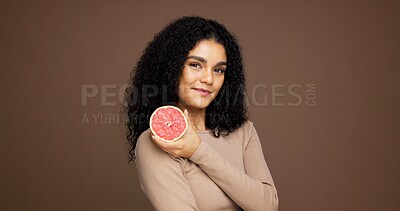 Buy stock photo Beauty, woman and smile with grapefruit in studio for skincare benefits, vitamin c or anti aging. Mockup space, girl and happy with fruit on brown background for exfoliation treatment or healthy skin
