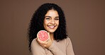 Beauty, girl and smile with grapefruit in studio for skincare, vitamin c or retinol antioxidants. Mockup space, woman or happy with fruit on brown background for exfoliation treatment or healthy skin