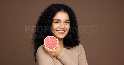 Buy stock photo Beauty, girl and smile with grapefruit in studio for skincare, vitamin c or retinol antioxidants. Mockup space, woman or happy with fruit on brown background for exfoliation treatment or healthy skin