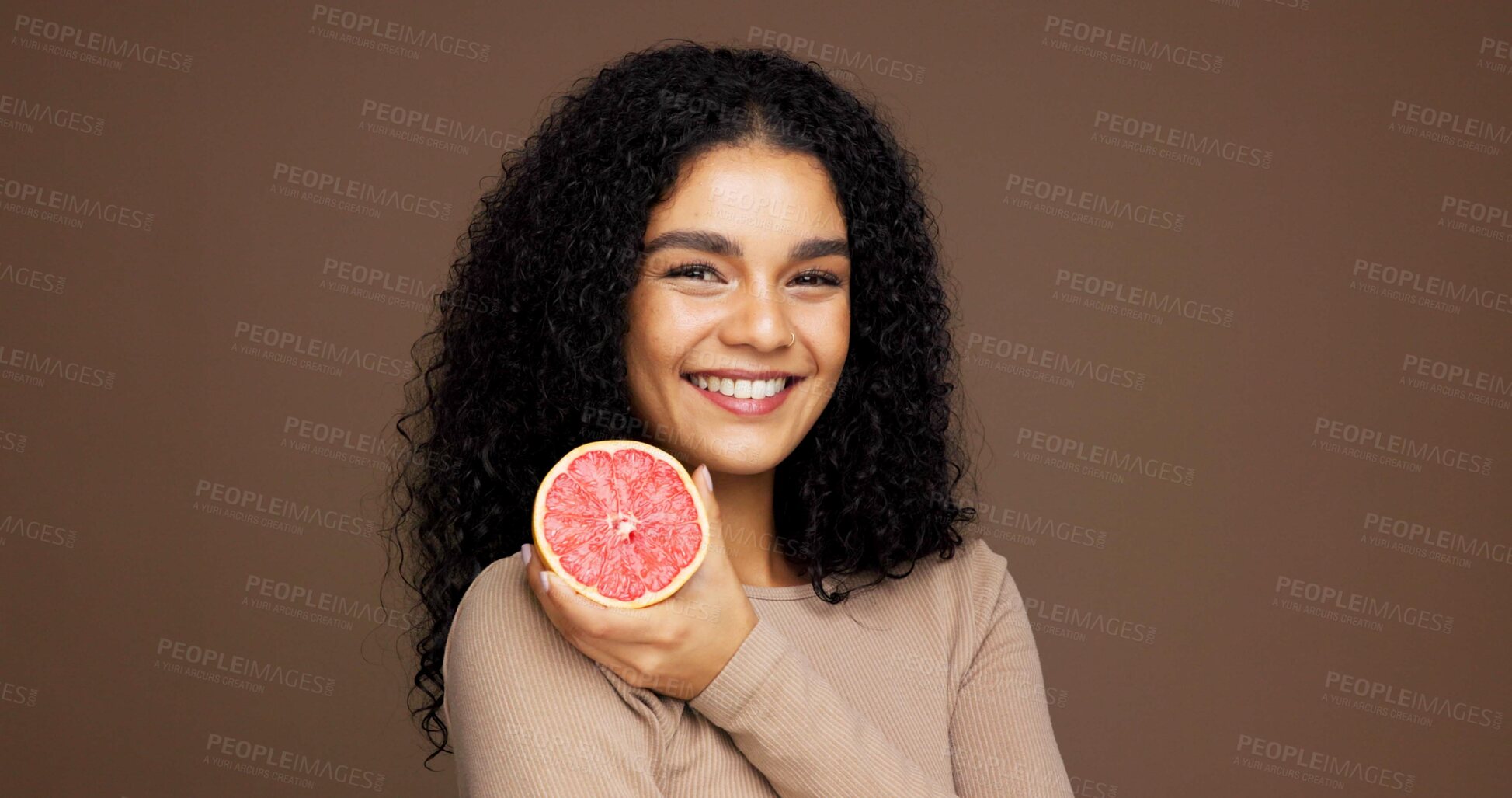 Buy stock photo Beauty, girl and smile with grapefruit in studio for skincare, vitamin c or retinol antioxidants. Mockup space, woman or happy with fruit on brown background for exfoliation treatment or healthy skin