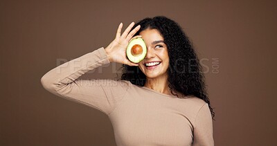 Buy stock photo Smile, woman and avocado for skincare in studio for vitamin c, brighten skin and natural detox. Female person, fruit and facial with organic benefits, beauty and hydration results on brown background