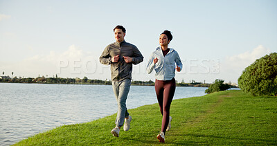 Buy stock photo Happy couple, fitness and running in nature by lake for workout, exercise or training together. Active, man and woman with smile on lawn for cardio, physical activity or marathon by riverside or pond